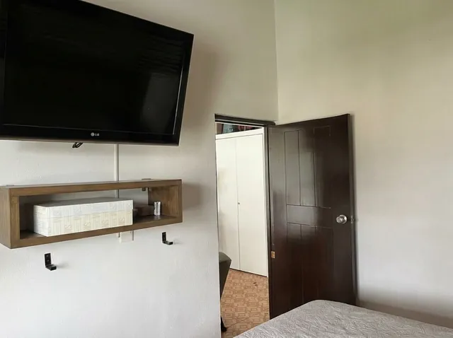Wall-mounted TV and wooden shelf